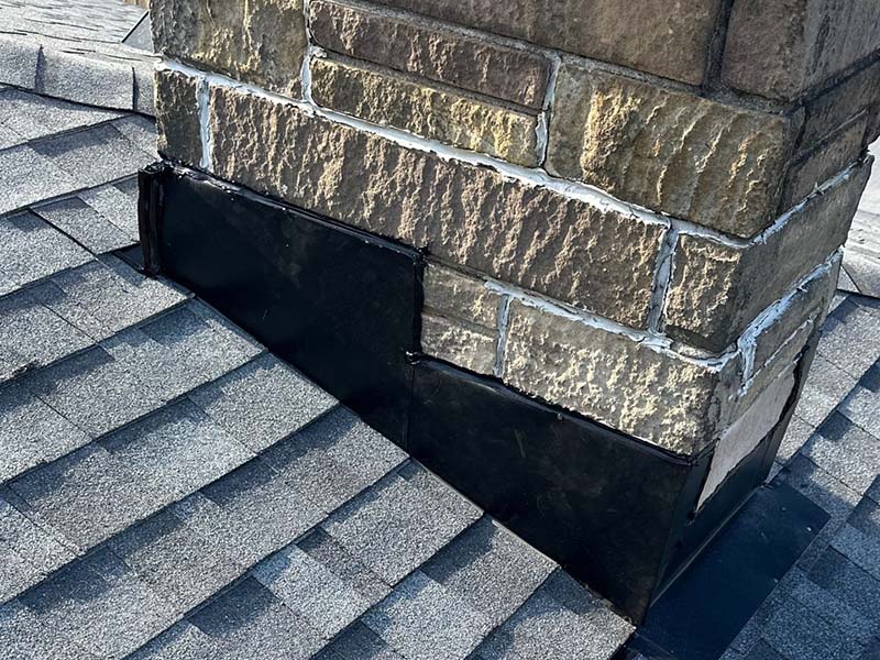 Completed residential roof replacement and chimney flashing