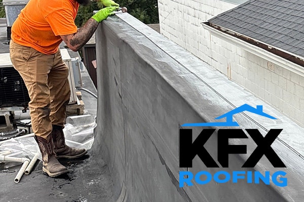 Roof repair specialist replacing EPDM rubber and flashing to flat roof parapet wall