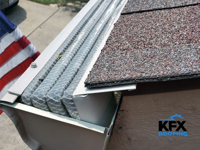 Micro-mesh gutter guard installed on white aluminum gutter with asphalt shingle roof edge visible